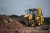 Żółto-czarna koparko-ładowarka JCB przenosząca ziemię - przykład maszyny budowlanej do renowacji specjalistyczną farbą Tikkurila Temadur 90.